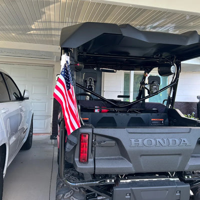 American flag strapped to the rear roll cage of a Honda Pioneer side-by-side