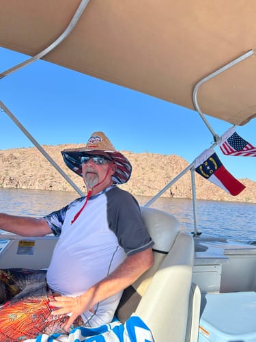 Customer's American Flag mounted on the canopy of a pontoon boat on the water.