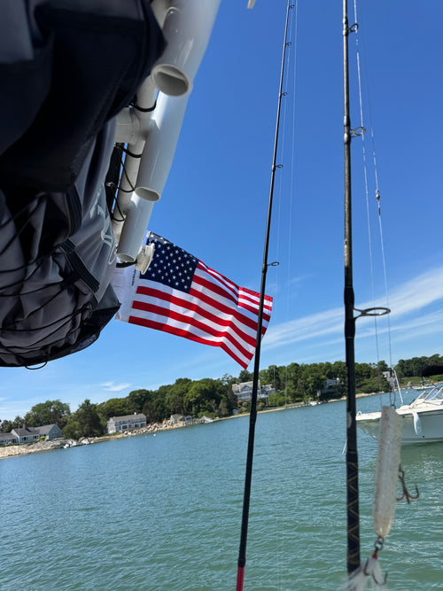 Customer's American Flag waving in the wind while attached to a boat on the water.