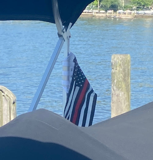 Customer photo review of Thin Red Line Flag (Firefighter Flag): the flag strapped to a pontoon boat's bimini frame.