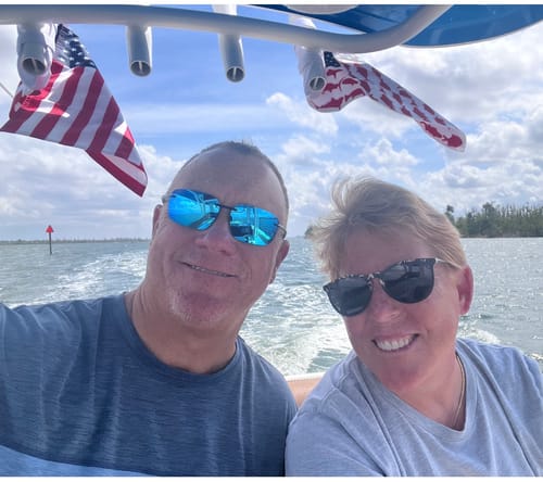 Customer on a boat with two American Flags mounted on the frame above them.