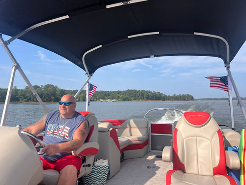 Reviewer's American Flags flying from the FlyAFlag system on a pontoon boat in the water.