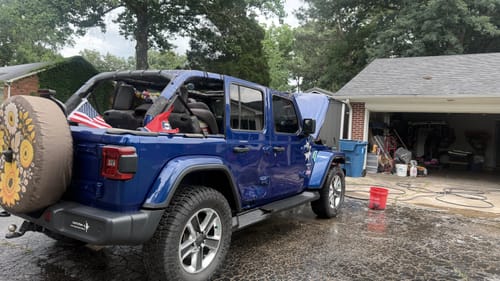 Tennessee Flag and an American flag attached to the roll bar of a blue Jeep.