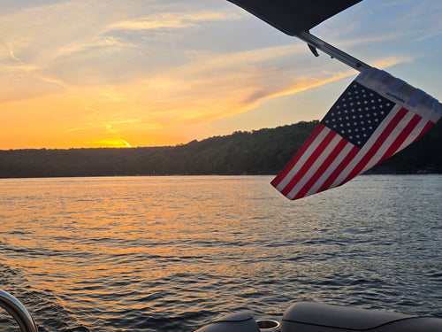 Customer's American Flag attached to a boat on a lake at sunset