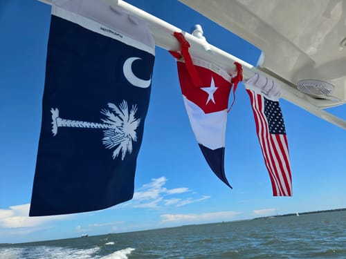 Customer's South Carolina Flag and American flag flying from their boat over the water.